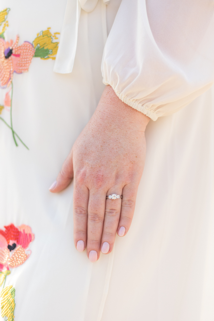 A close up of the ring by Brogan's side in front of her dress